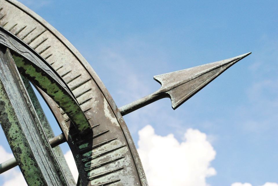 Close up of edge of sundial with arrow